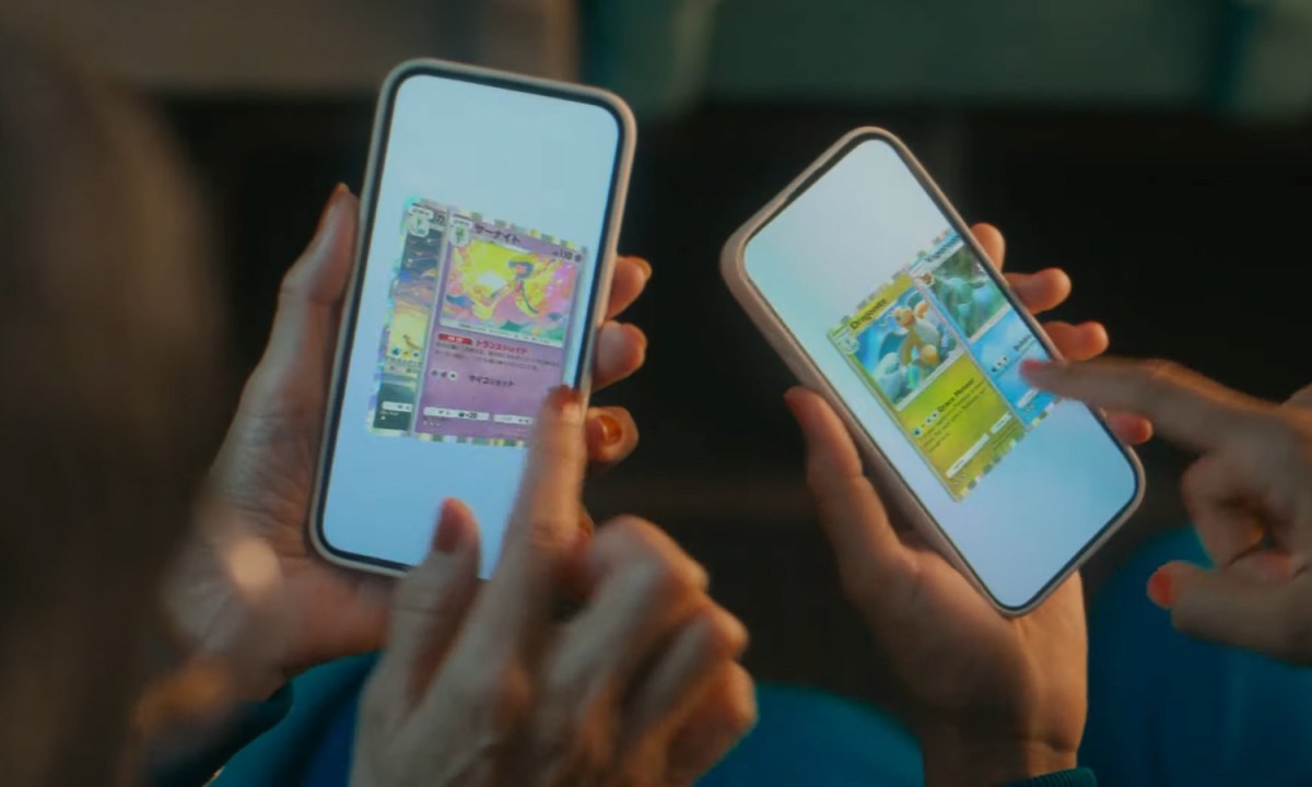 Two people holding their phones playing Pokemon TCGP.