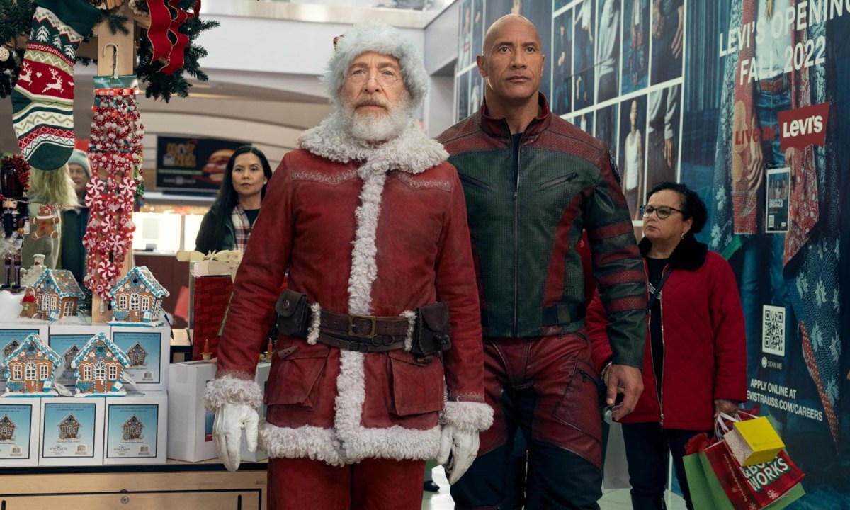 Santa Claus stands next to Dwayne Johnson and they walk together.