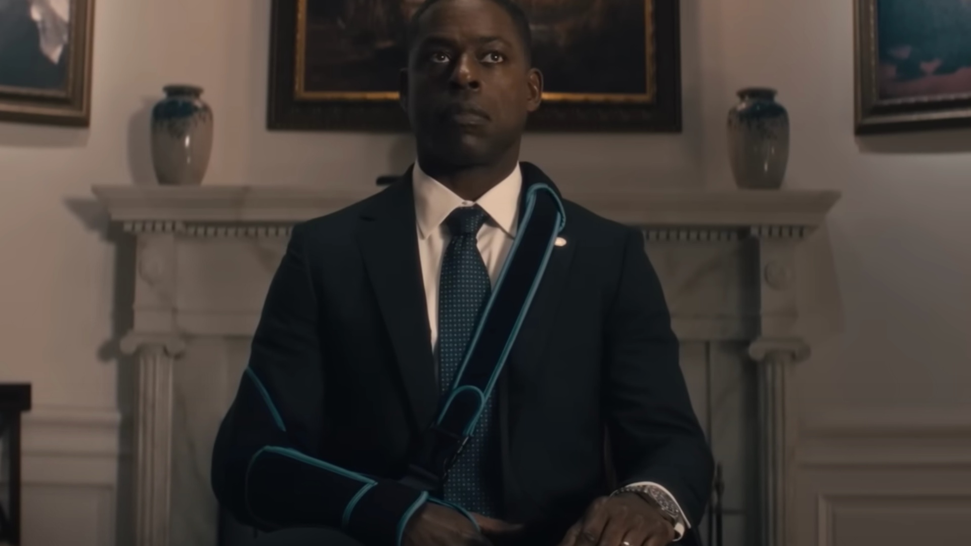 Sterling K. Brown sits in a chair while wearing a sling.