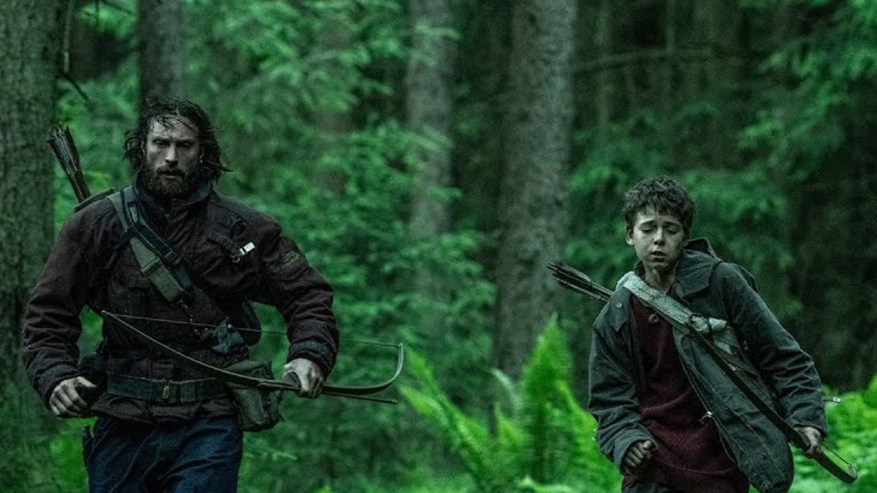 A man and a boy run with bows in their hands in 28 Years Later.