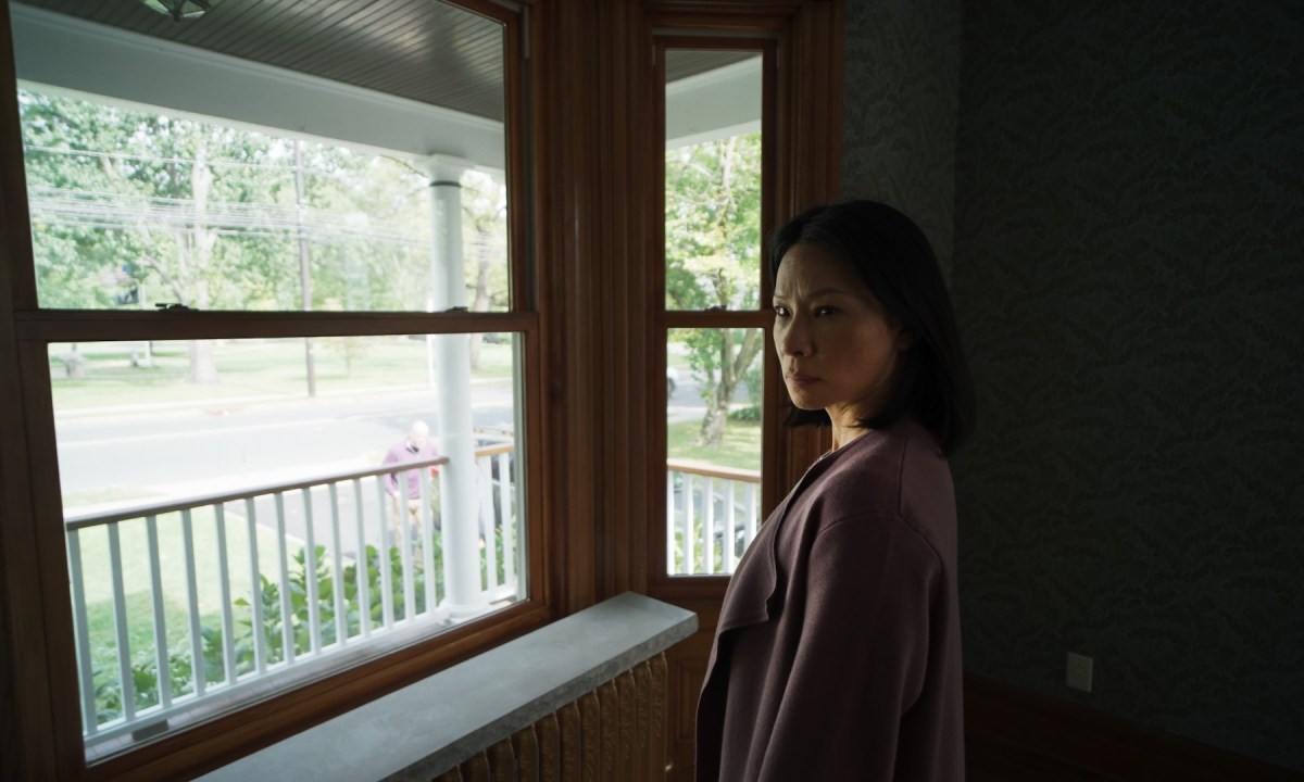 Lucy Liu stands in front of a window in Presence.