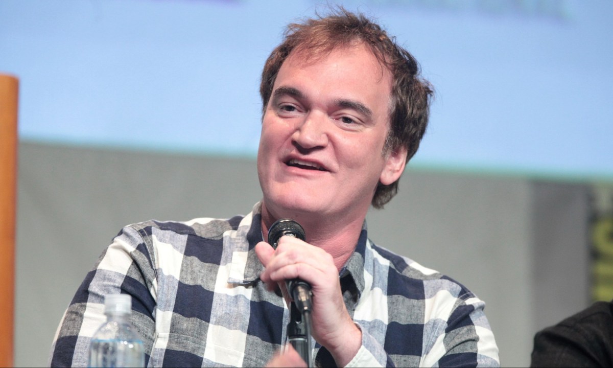 Quentin Tarantino holds a mic and talks at Comic Con.