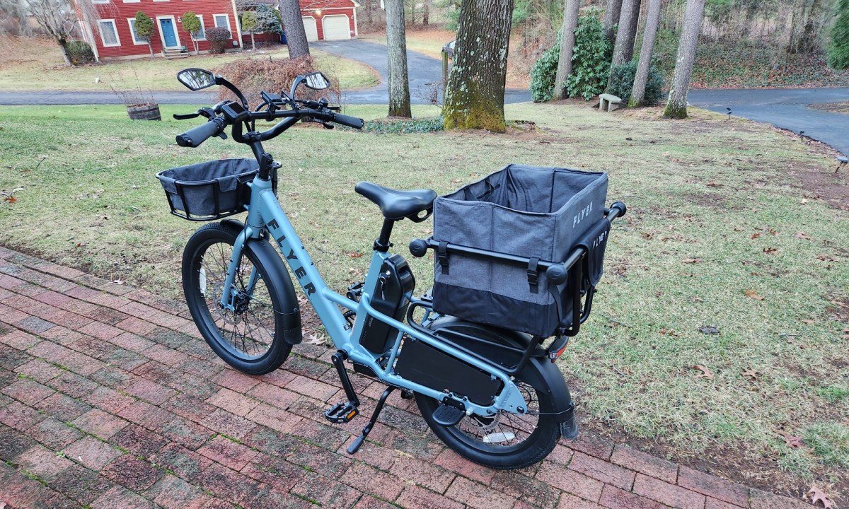 Radio Flyer Flex e-bike left rear three-quarter view with optional cargo and carry bag in hopper.