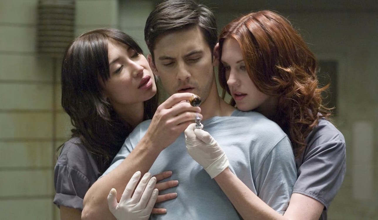Two women surround a man in Pathology.