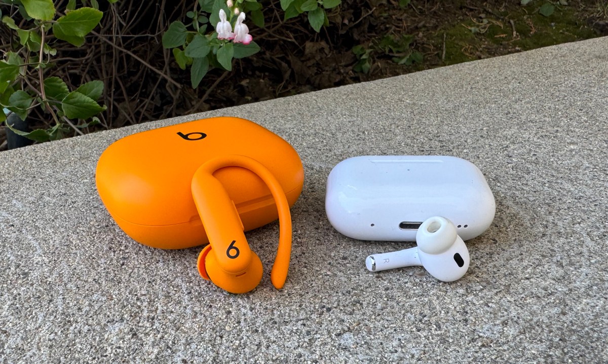 The Apple AirPods Pro 2 and Beats Powerbeats Pro 2 cases and earbuds next to one another on a stone step.