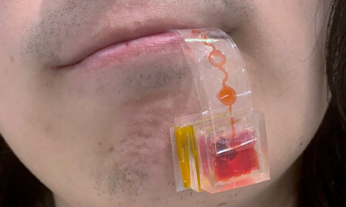 A person’s lips holding the e-Taste sensor kit.