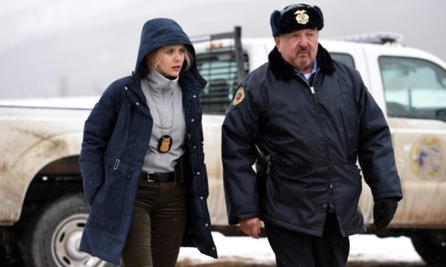 A female cop and a male cop walk next to each other.