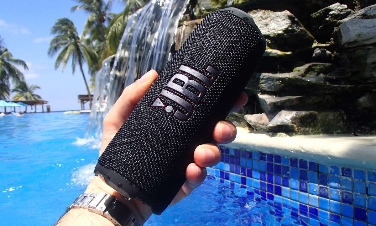 JBL Flip 7 hand-held near a pool.