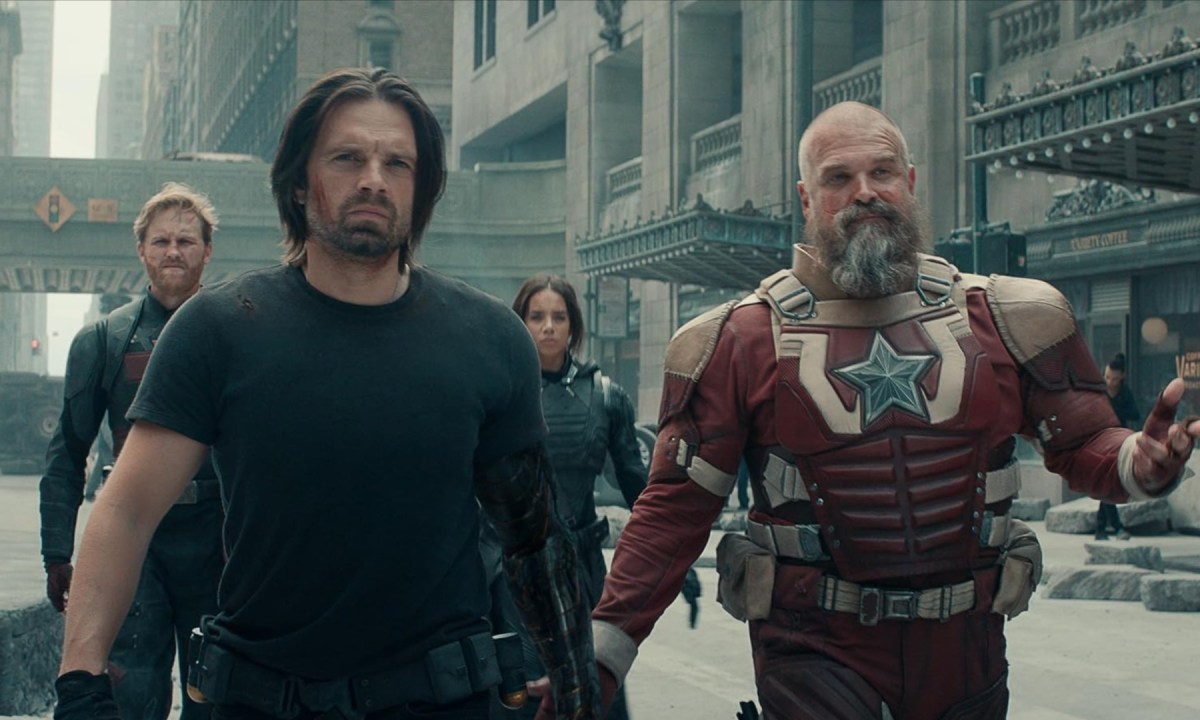 A group of superheroes walk in unison toward camera.