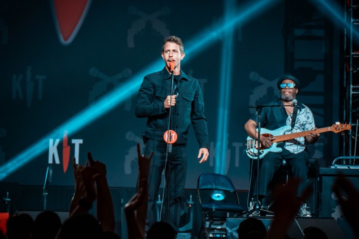 A man stands with a mic in front of him.