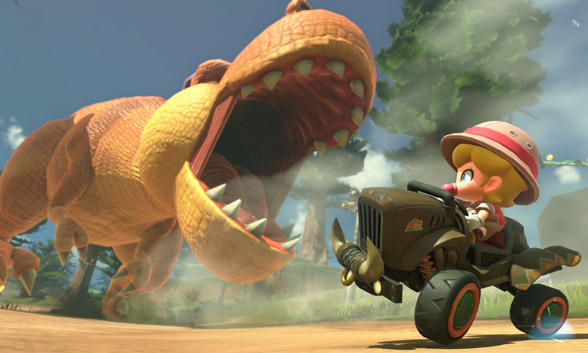 Baby Peach rides away from a T-rex in Mario Kart World.